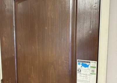 A solid Knotty Alder front door with a rich wood grain finish and a label detailing product specifications.